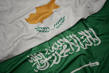 waving colorful flag of saudi arabia and national flag of cyprus.
