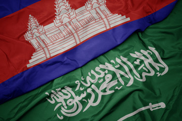 waving colorful flag of saudi arabia and national flag of cambodia.