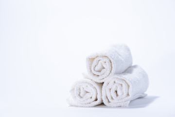 Obraz na płótnie Canvas Gently rolled terry towels for spa or massage on a white background