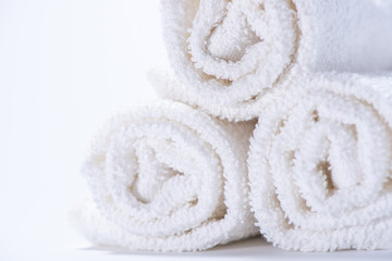 Fototapeta na wymiar Gently rolled terry towels for spa or massage on a white background