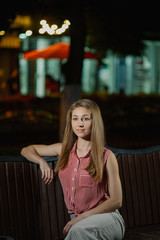 Nice girl on a bench in the evening in the park.