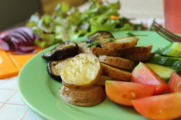 baked potatoes and eggplants with fresh tomatoes, herbs and greens