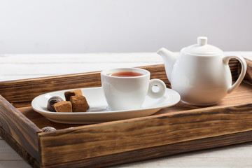 cup of tea with chocolate candy on wooden table