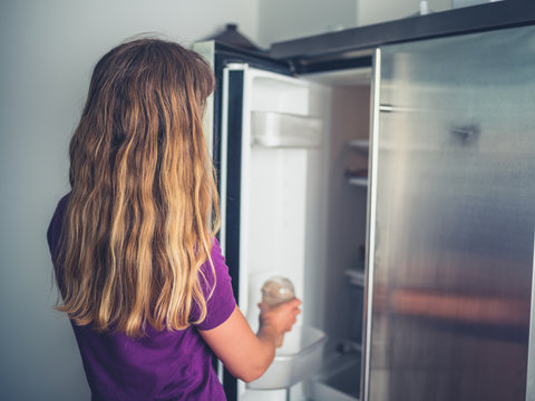 Woman getting a drink from the fridge