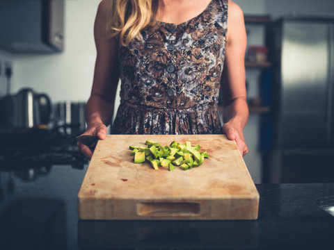 Young woman chopping avocado