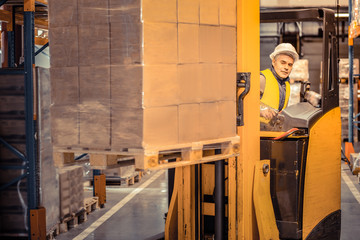 Fototapeta na wymiar Kind grey-haired male person working on warehouse