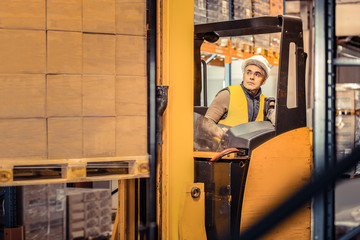 Attentive grey-haired male person working on warehouse