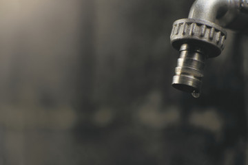 Close up faucet and drop of water ,shortage and drought concept.