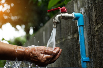 Old hand and faucet ,Water shortage and drought concept.