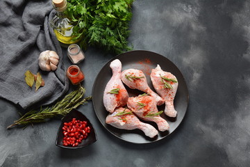 Raw uncooked chicken legs for barbecue grill with salt, herbs, garlic and olive oil. Meat with ingredients for cooking