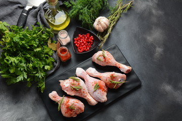 Fototapeta na wymiar Raw uncooked chicken legs for barbecue grill with salt, herbs, garlic and olive oil. Meat with ingredients for cooking