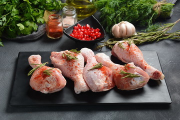 Raw uncooked chicken legs for barbecue grill with salt, herbs, garlic and olive oil. Meat with ingredients for cooking