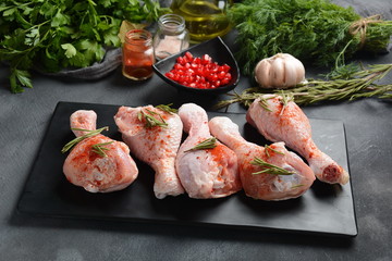 Raw uncooked chicken legs for barbecue grill with salt, herbs, garlic and olive oil. Meat with ingredients for cooking