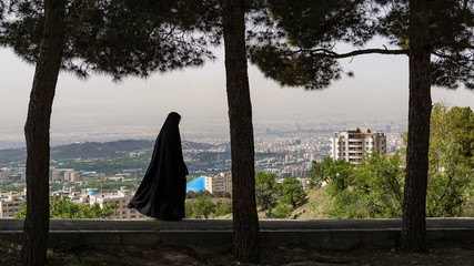 veiled woman with the background of Tehran city aerial view, Iran