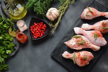 Raw uncooked chicken legs for barbecue grill with salt, herbs, garlic and olive oil. Meat with ingredients for cooking