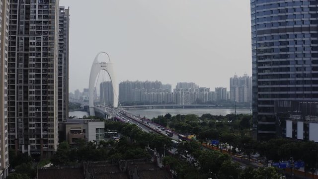 View of Liede Bridge with heavy traffic, cars, taxis, public transport moving over the Zhujiang river in downtown of Guangzhou, Guangdong, China, Asia, Aerial Shot.