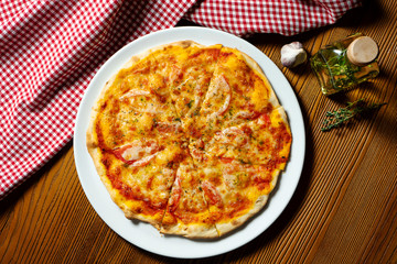 Fresh homemade Margarita pizza on a wooden background in composition with a red cloth and olive oil. Italian Cuisine. Top view food photo