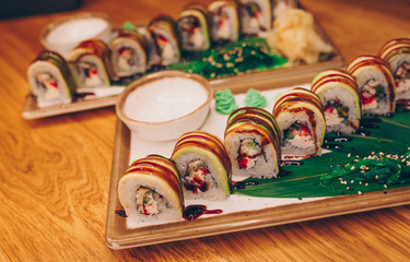 Close-up Set Philly california avocado eel smoked Red Green dragon California ,Ebi Roll philadelphia rolls assorti ginger seaweed in night dining restaurant. Delicious Sushi rolls served in a bar.