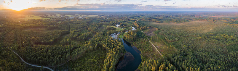 Aerial view of river among the forest. Summer nature landscape. Sunset.