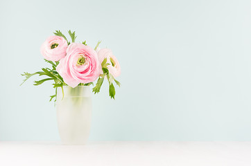 Delicate home decor with pink buttercup flowers on white wood table and mint color wall, background for design for gift, holiday, valentine day, wedding.