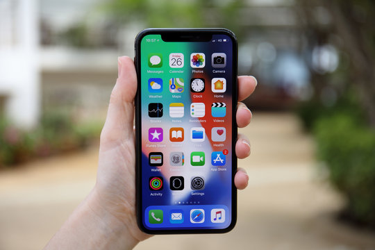 Woman hand holding iPhone X with IOS 11 on screen