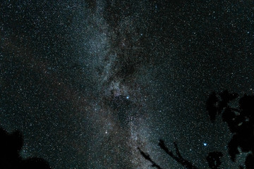 Fototapeta premium Overhead milky way with stars in clear summer night. Old barn house. Country side.