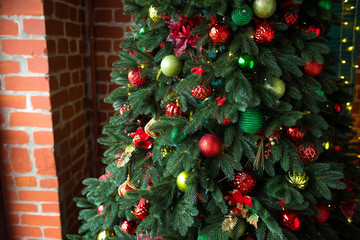 Green Christmas tree decorated with Christmas gifts and a garland. New Year.