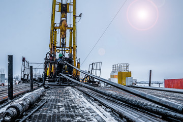 Workover rig working on a previously drilled well trying to restore production through repair. Toned