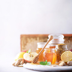 Alternative medicine concept. Ingredients for flu fighting natural hot drink. Copy space. Lemon, ginger, mint, honey, apple and spices on grey background