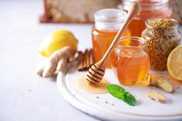 Ingredients for healthy hot drink. Lemon, ginger, mint, honey, apple and spices on grey background. Copy space. Alternative medicine concept. Clean eating, detox