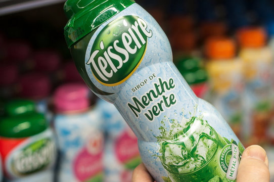 Mulhouse - France - 22 February 2018 - closeup of green Mint syrup in hand from Teisseire brand at Super U supermarket , with french text, "Menthe verte", traduction in english : green Mint.