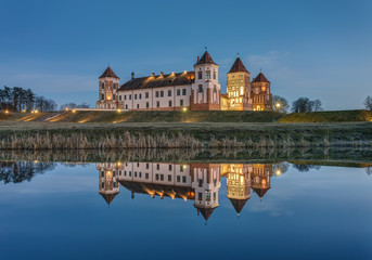Naklejka na ściany i meble Mir, Belarus - March 28, 2019: Mir Castle complex and its reflection at sunset, UNESCO World Heritage Site.