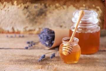 Herbal honey with lavender flowers, bee pollen granules, honey conb on grey background. Autumn harvest concept