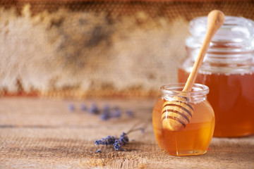 Herbal honey with lavender flowers, bee pollen granules, honey conb on grey background. Autumn...