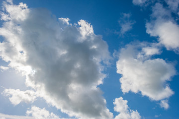 Naklejka na ściany i meble White clouds in a blue sky in sunlight at fall