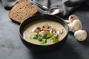 A bowl of Mushroom Cream Soup with fried champignons and fresh parsley. Winter, autumn hot soup concept 