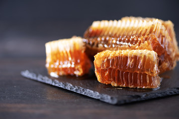 Fresh honeycombs pieces, dry lavender flowers on black background. Autumn harvest concept
