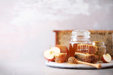 Apples with honey jar, honeycomb on grey background with copy space. Rosh hashanah jewish new year holiday celebration