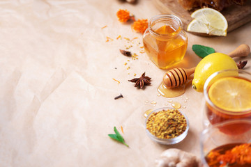 Autumn harvest concept. Set of honey and bee products, apple, lemon, spices on craft paper background. Immune system support with alternative medicine