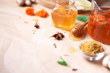 Alternative medicine concept. Ingredients for flu fighting natural hot drink. Copy space. Lemon, ginger, mint, honey, apple and spices on craft paper background