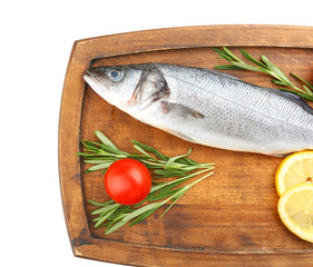 Board with fresh seabass fish, lemon, rosemary and tomato on white background