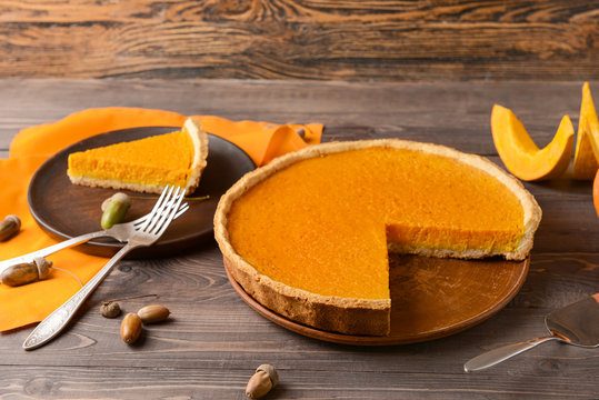 Composition with tasty pumpkin pie on wooden background