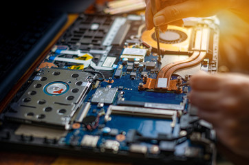 Technician repairing broken laptop notebook computer