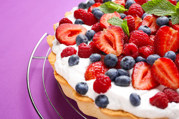 Tasty berry pie on color background, closeup