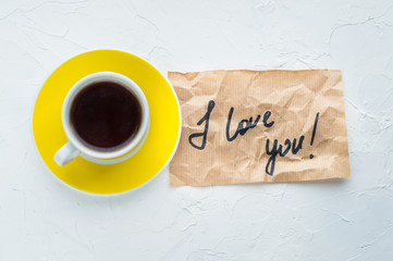 Yellow cup of coffee on a white background. Minimalism. Top view. I love you. Close up. Concept St. Valentine's Day