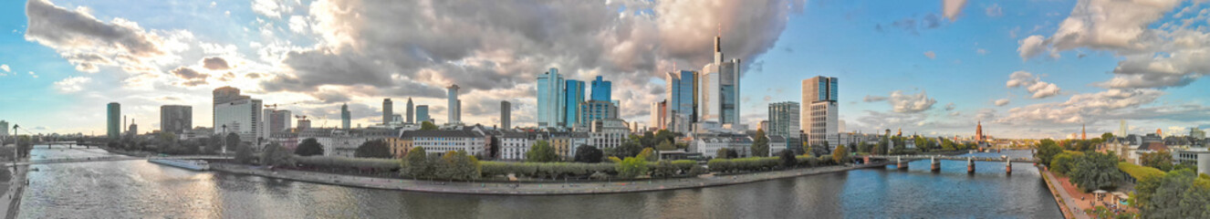 Obraz premium Aerial flying along the futuristic skyline the business and financial centre of Frankfurt am Main, sunset panoramic view from drone