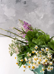 Armful of fresh medicinal plants in a box on the table
