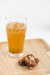Glass of passion fruit tea, Refreshing summer drink and  dessert on wood plate and minimal style background.