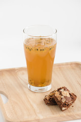 Glass of passion fruit tea, Refreshing summer drink and  dessert on wood plate and minimal style background.