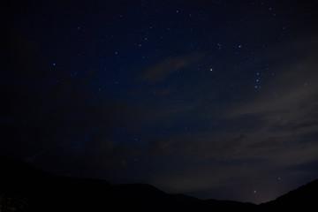 Stars in the night sky overhead. Night starry sky over the mountains. Stars and constellations in the sky.